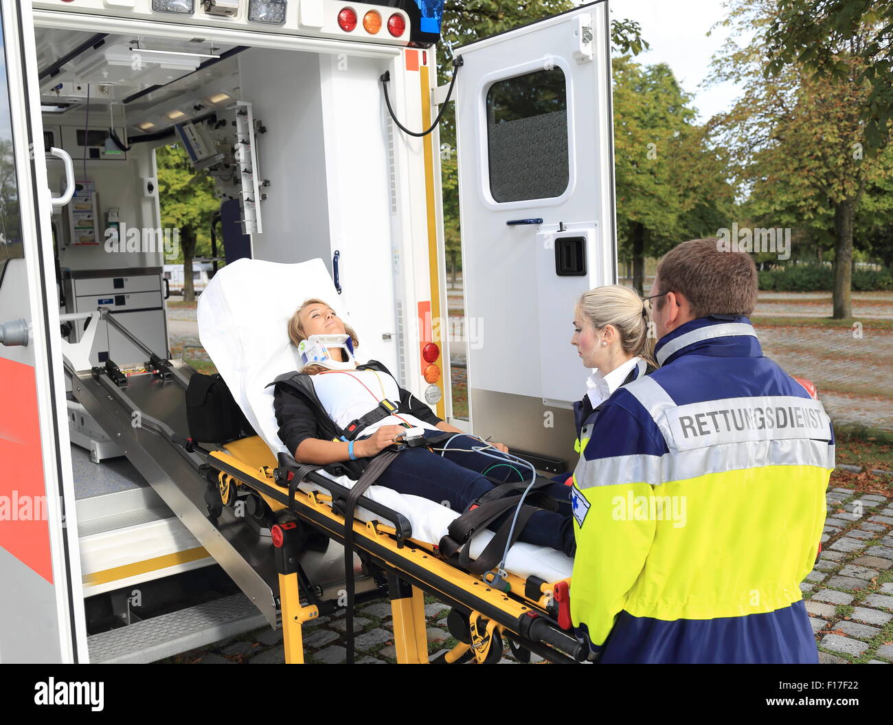 A Women on stretcher with stiffneck and Ambulance after accident Stock Photo