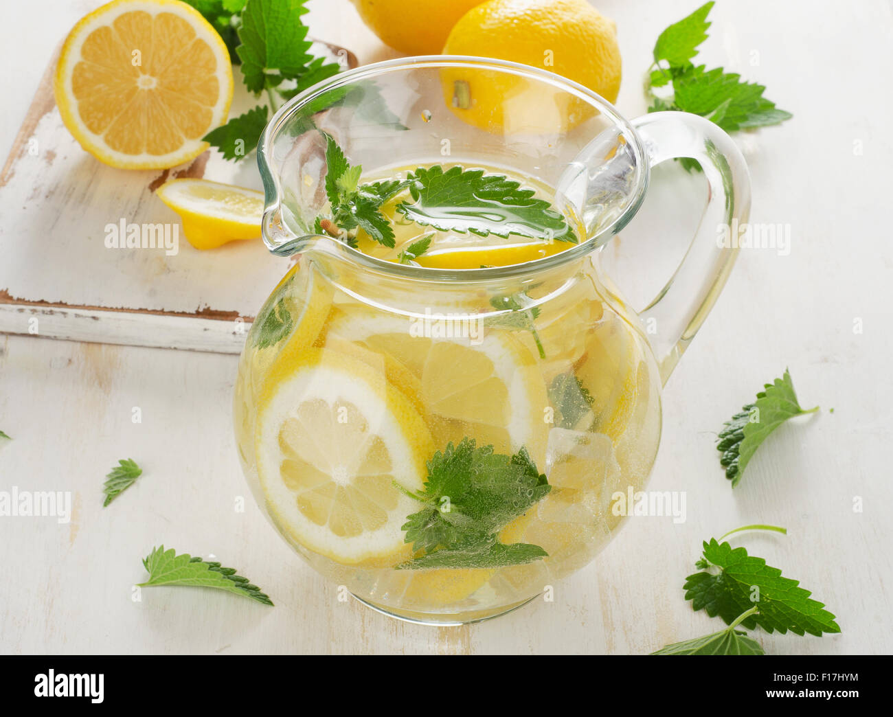 Cold Water with fresh lemon and mint leaves in a glass jug Stock Photo