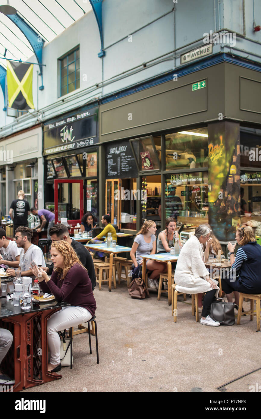 Brixton Village market, London, UK. People enjoy food and drink in Brixton Village, Brixton's iconic covered market. Stock Photo