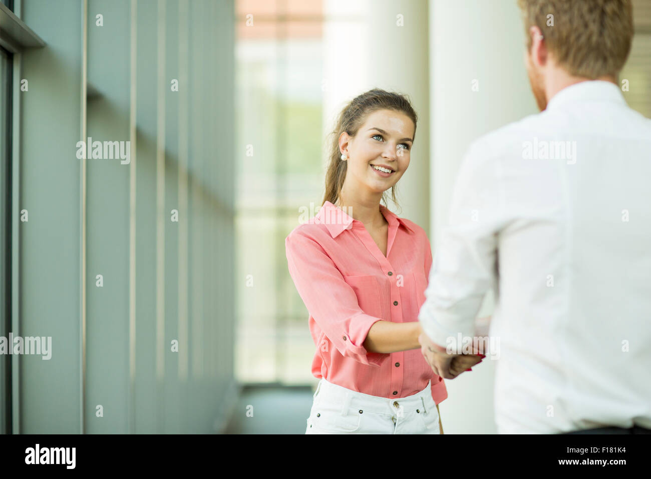 Young woman and man handshaking Stock Photo - Alamy