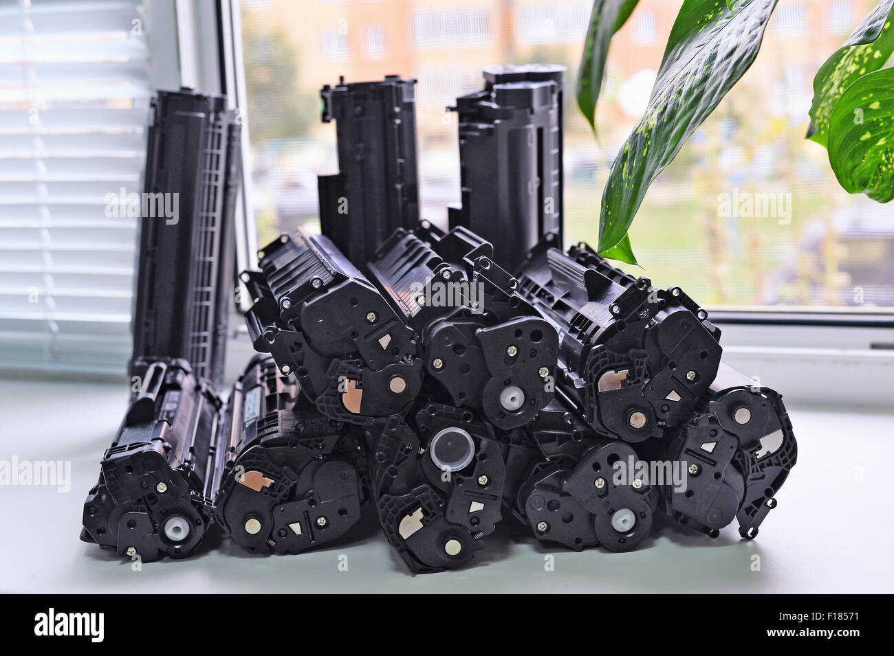 Empty cartridges from the printer stacked on the windowsill of the office. Waste production. Stock Photo