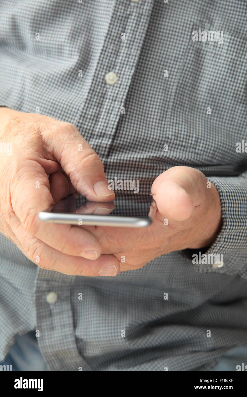 Man in checked shirt using his mobile device Stock Photo