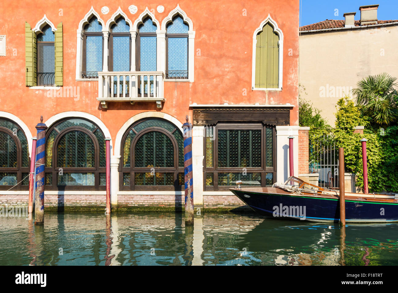 Wooden boat moored against an ochre coloured building on Rio del Malcanton, Santa Croce, Venice, Italy Stock Photo