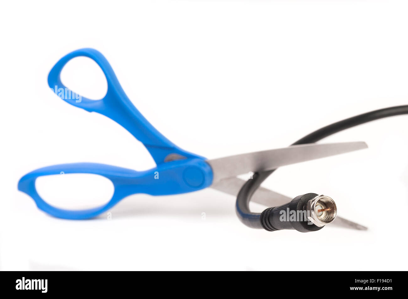 Scissors cutting through a coaxial RG6 cable - cut the cable tv concept isolated on white background Stock Photo
