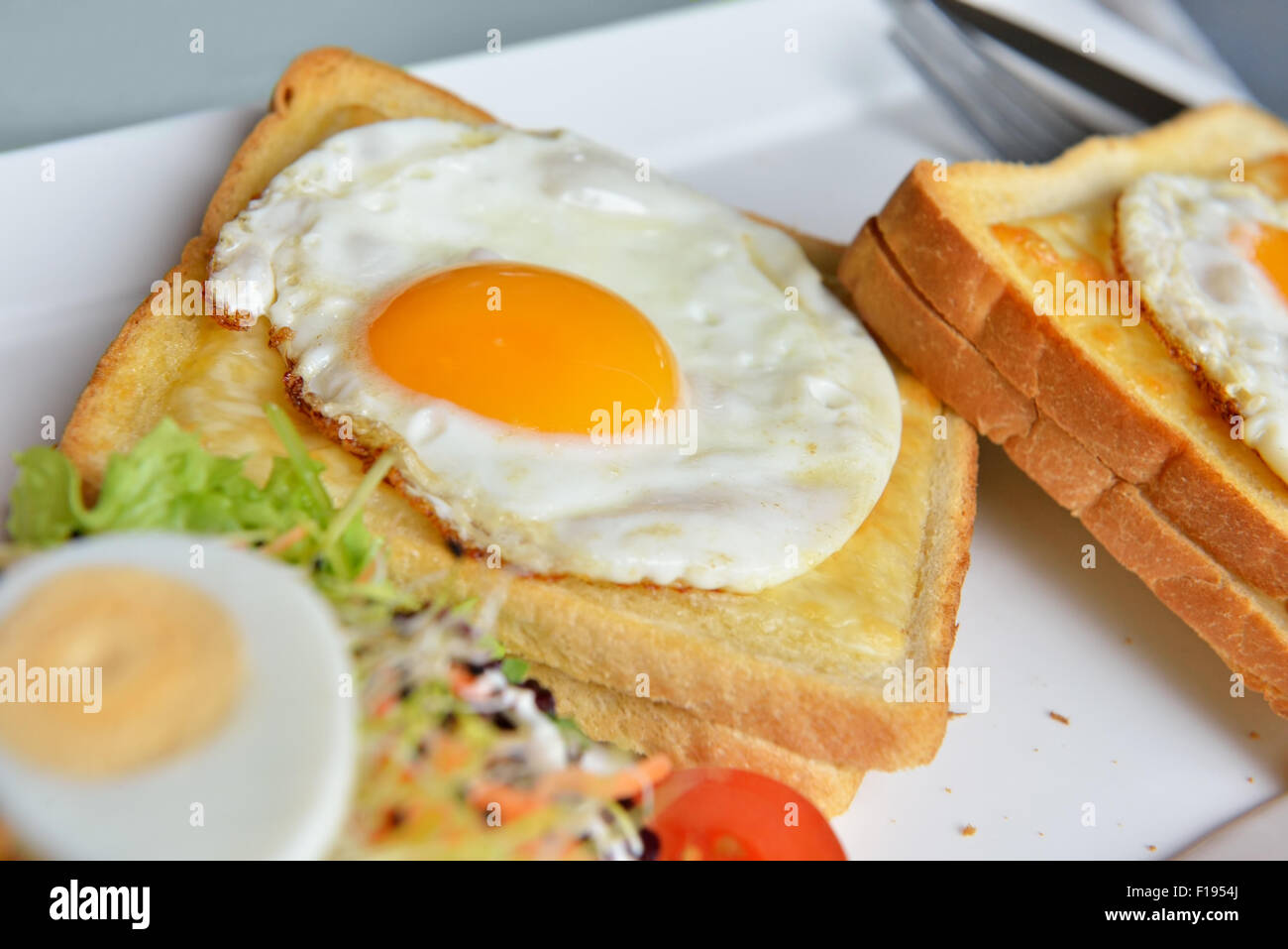 Dish croque-madame with beautiful fried eggs, bread and ham, shallow DOF in natural light closeup image Stock Photo