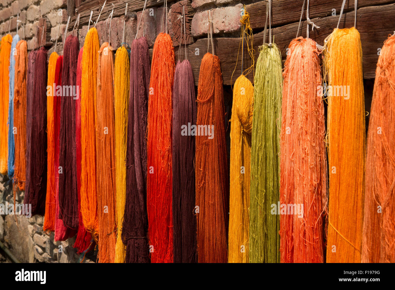 India, Jammu & Kashmir, Srinagar, Old City, crafts, dyed warm coloured embroidery threads hanging on fence to dry Stock Photo