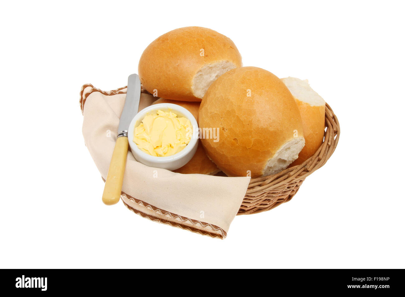 Crusty bread rolls with butter a knife and serviette in a basket