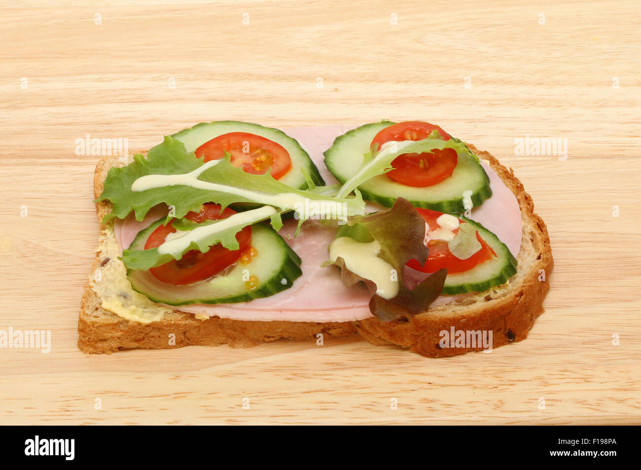 Ham and salad open sandwich with salad cream on a wooden board Stock Photo