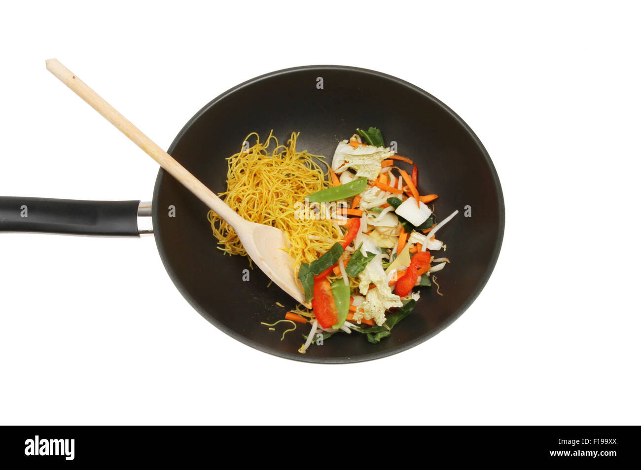Stir fry ingredients with a wooden spoon in a wok isolated against white Stock Photo
