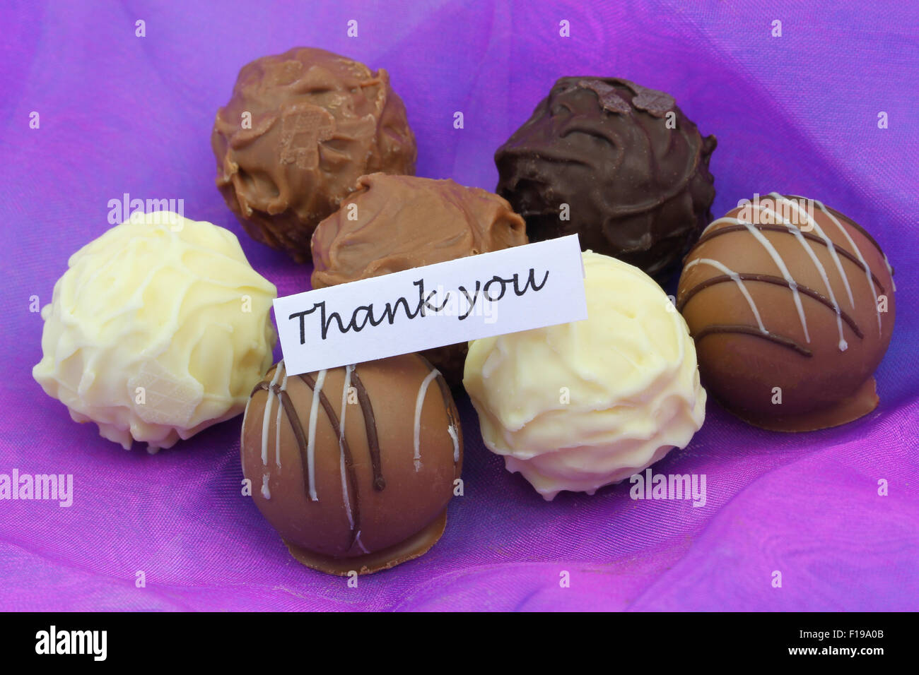 Thank you card with assorted chocolates on purple background Stock Photo