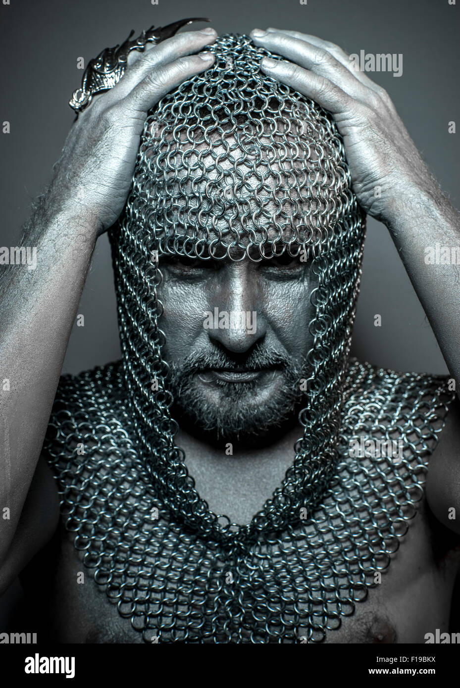 Hooded, medieval executioner mesh iron rings on the head Stock Photo