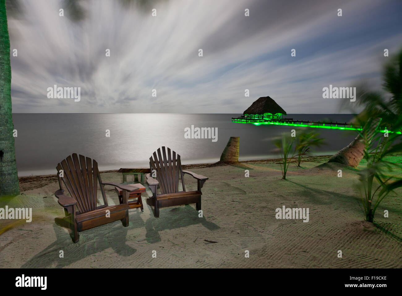 A night time beach with moonlight and green accent lights highlighting