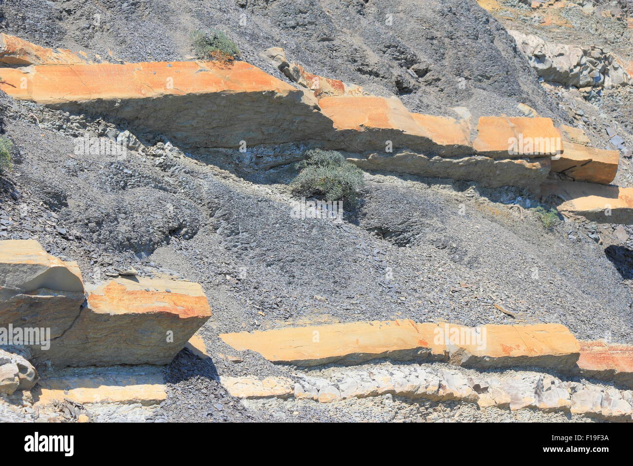 Steep slopes with sparse vegetation and visible layers of rock Stock ...