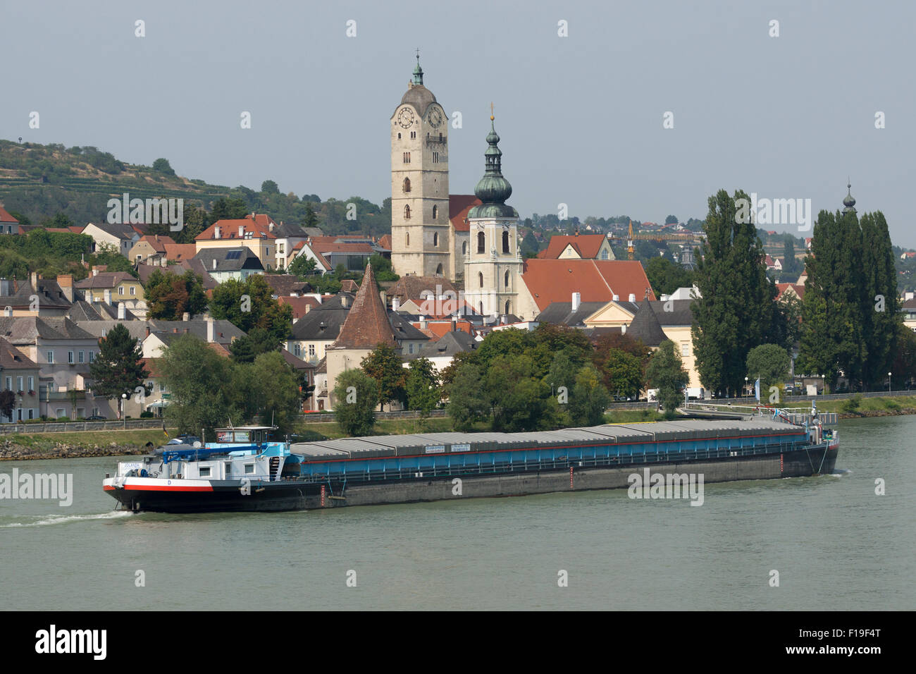 A commercial barge carrying goods passing by Stein an der Donau on the River Danube in Lower Austria Stock Photo