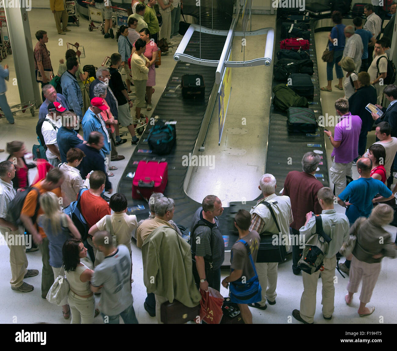 People at the airport waiting for their luggage at the Baggage conveyor belt Stock Photo