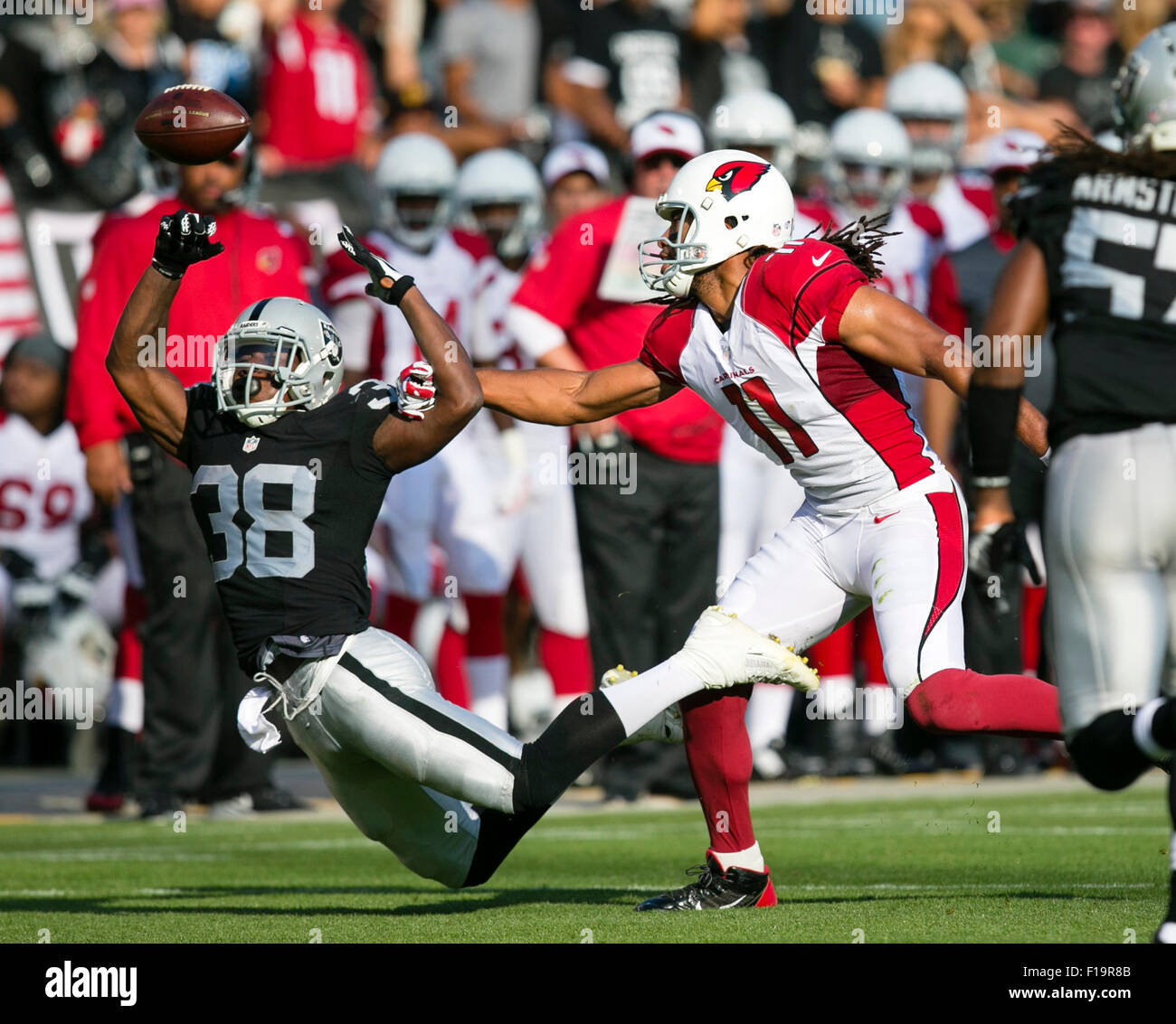 Oakland, CA. 30th Aug, 2015. Oakland Raiders cornerback T.J. Carrie (38) breaks up a pass intended for Arizona Cardinals wide receiver Larry Fitzgerald (11) during the NFL football game between the Oakland Raiders and the Arizona Cardinals at the O.co Coliseum in Oakland, CA. The Cardinals defeated the Raiders 30-23. Damon Tarver/Cal Sport Media/Alamy Live News Stock Photo