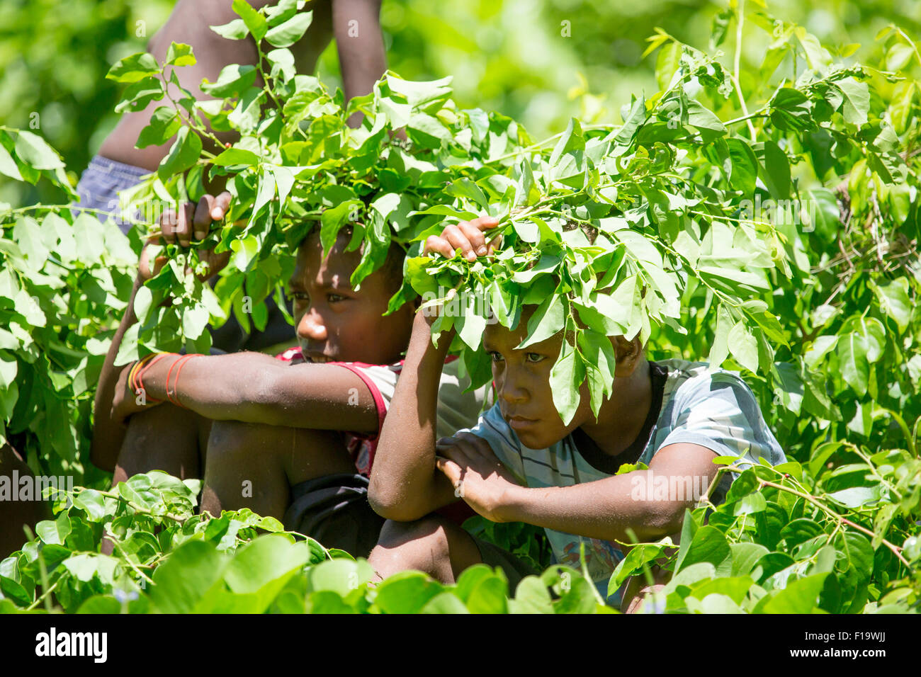 Solomon Islands, Makira-Ulawa Province, Owaraha aka Santa Ana, local kids seek shade from sun. Stock Photo