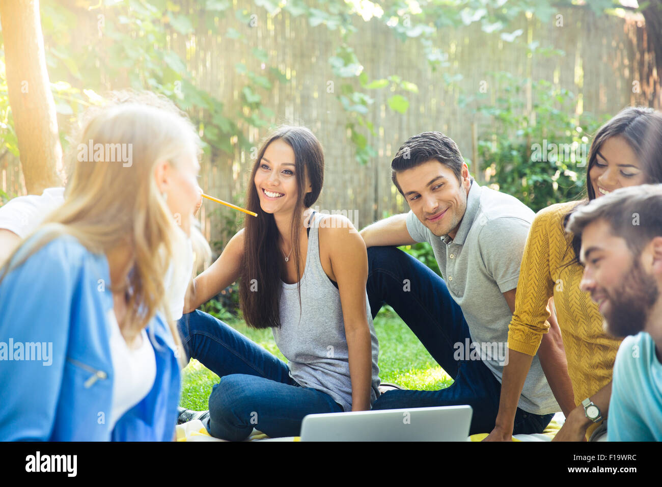 Happy friends laptop sitting hi-res stock photography and images - Alamy