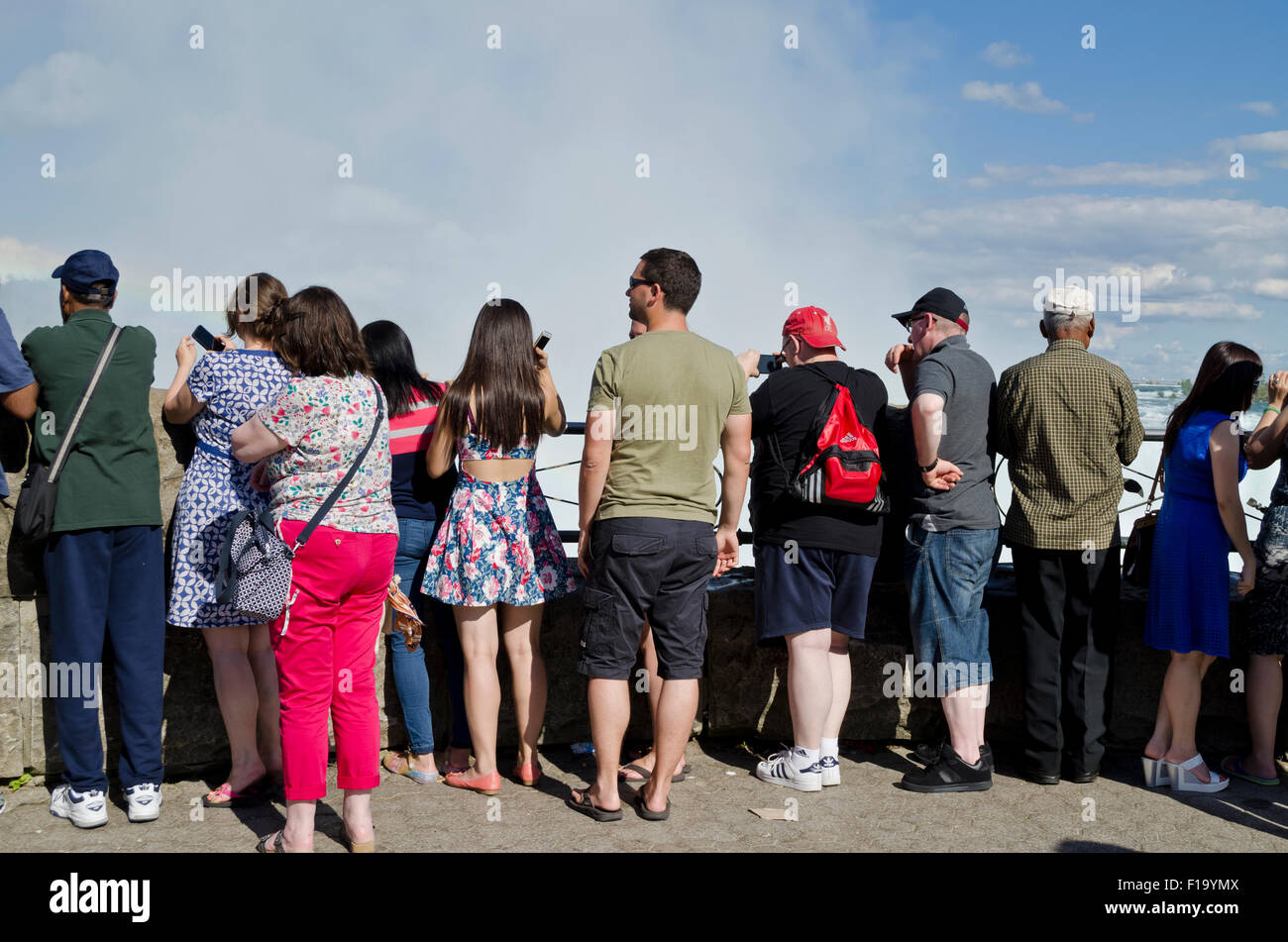 Crowds of tourists watch and take photos of Niagara Falls from the Canadian side. Group of people viewing the Horseshoe Falls. Stock Photo