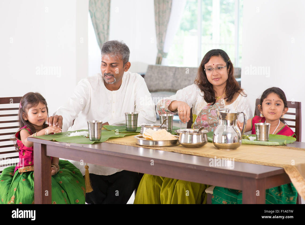 Indian family dining at home. Photo of Asian people eating rice with hands. India culture. Stock Photo