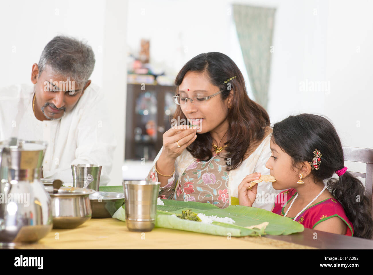 Indian family dining at home. Candid photo of India people eating rice with hands. Asian culture. Stock Photo