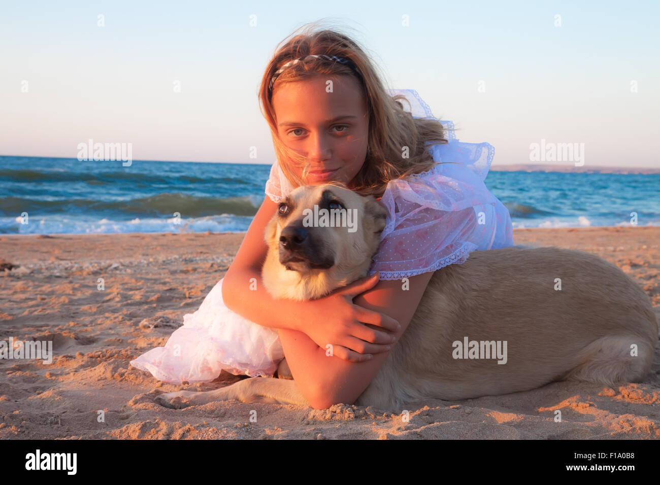friendship concept girl with her dog lying outdoors Stock Photo