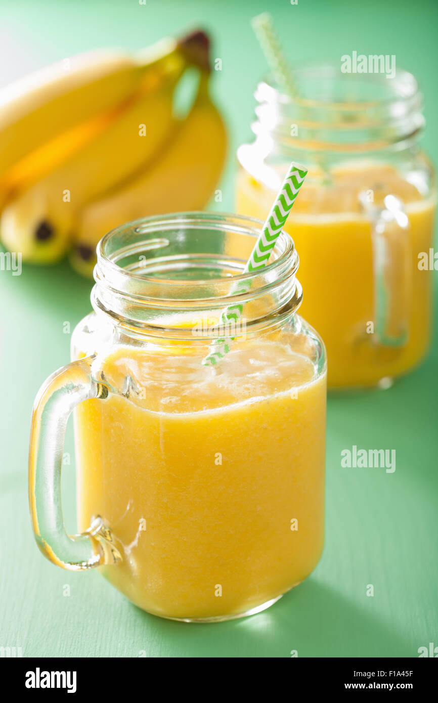 healthy yellow smoothie with mango pineapple banana in mason jars Stock