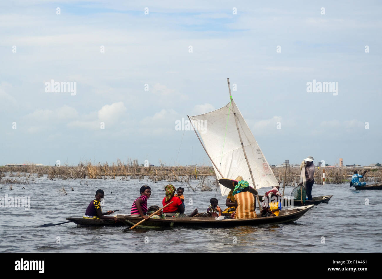 African people navigating in Ganvié, the 'Venice of Africa', village of stilt houses on a lake near Cotonou in Benin Stock Photo