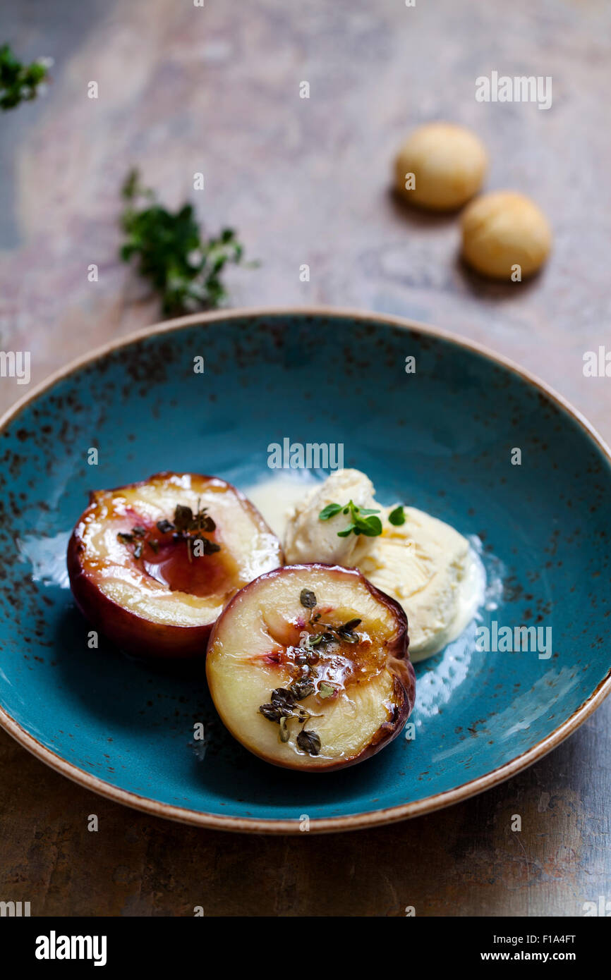 Baked peach with thyme, ice cream and amaretti biscuits Stock Photo Alamy