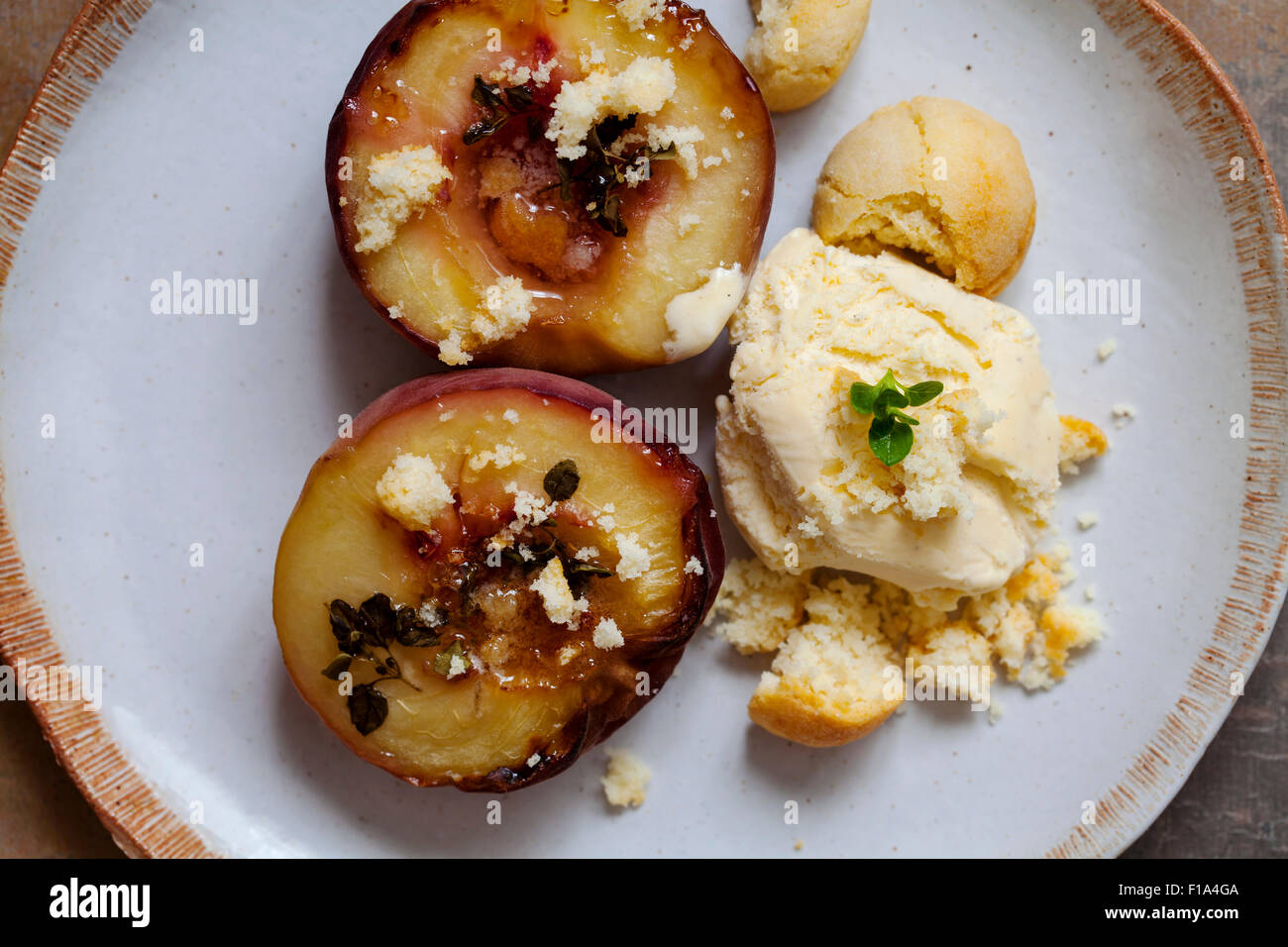 Baked peach with thyme, ice cream and amaretti biscuits Stock Photo Alamy