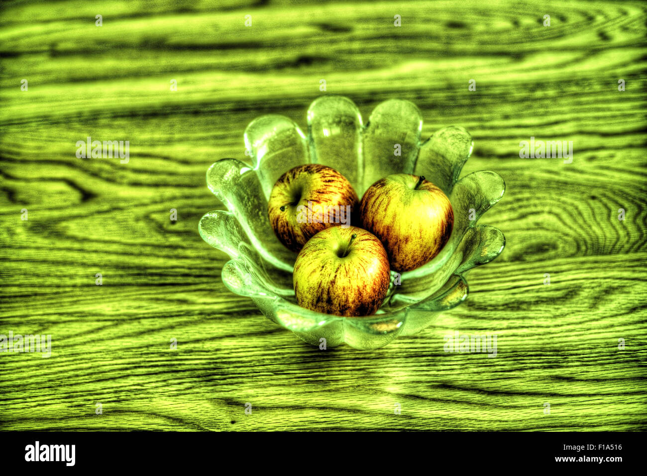 Apples in a glass bowl on a wooden table, processed as an HDR image. Stock Photo