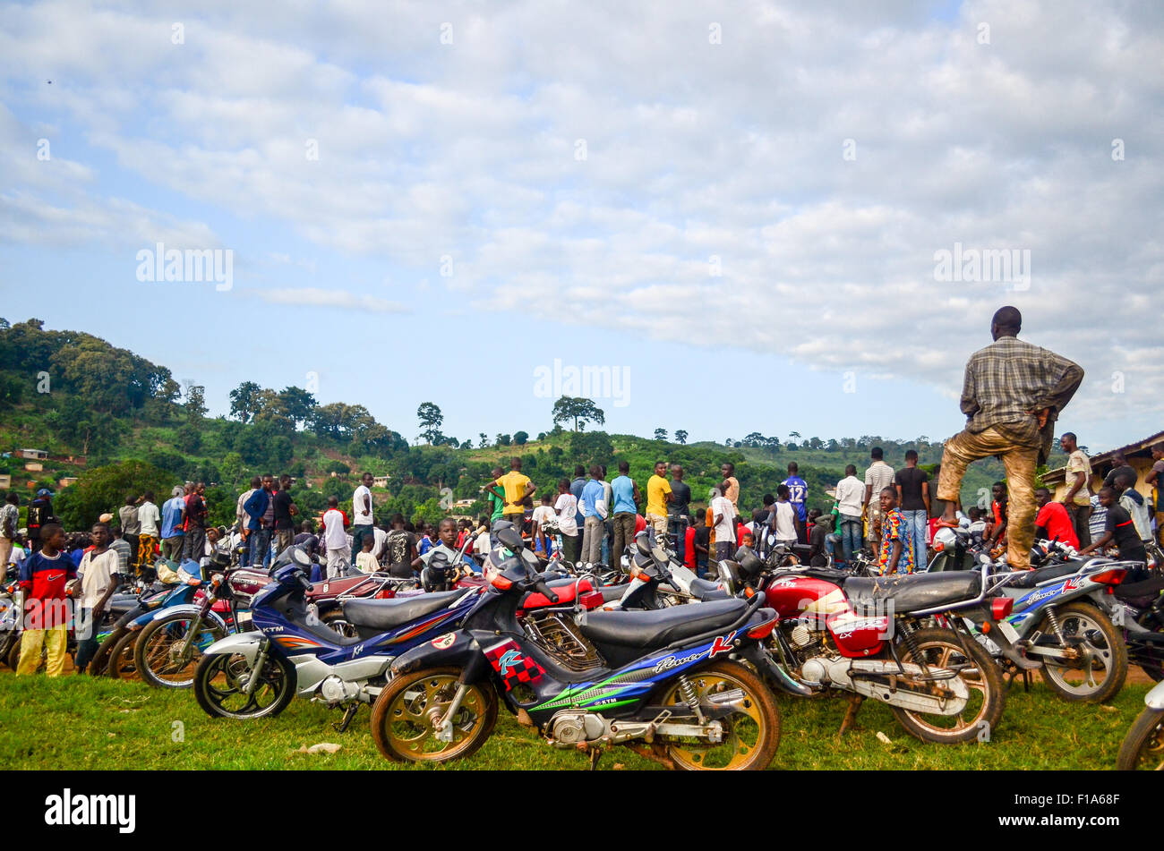 Crowd watching a football game from their motorbikes in Man, Ivory Coast Stock Photo