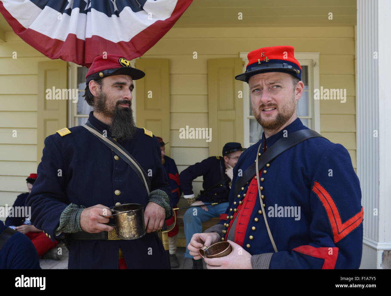Old Bethpage, New York, USA. 30th Aug, 2015. L-R at front, Andrew Preble from Long Beach, and Matt Dellinger from Brooklyn, portray American Civil War soldiers from the 14th Brooklyn Regiment (14th New York State Militia) AKA The Brooklyn Chasseurs, at the Noon Inn tavern during the Old Time Music Weekend at the Old Bethpage Village Restoration. During their historical reenactments, members of the non-profit 14th Brooklyn Company E wear accurate reproductions of ''The ''Red Legged Devils'' original Union army uniform. Credit:  Ann Parry/ZUMA Wire/Alamy Live News Stock Photo