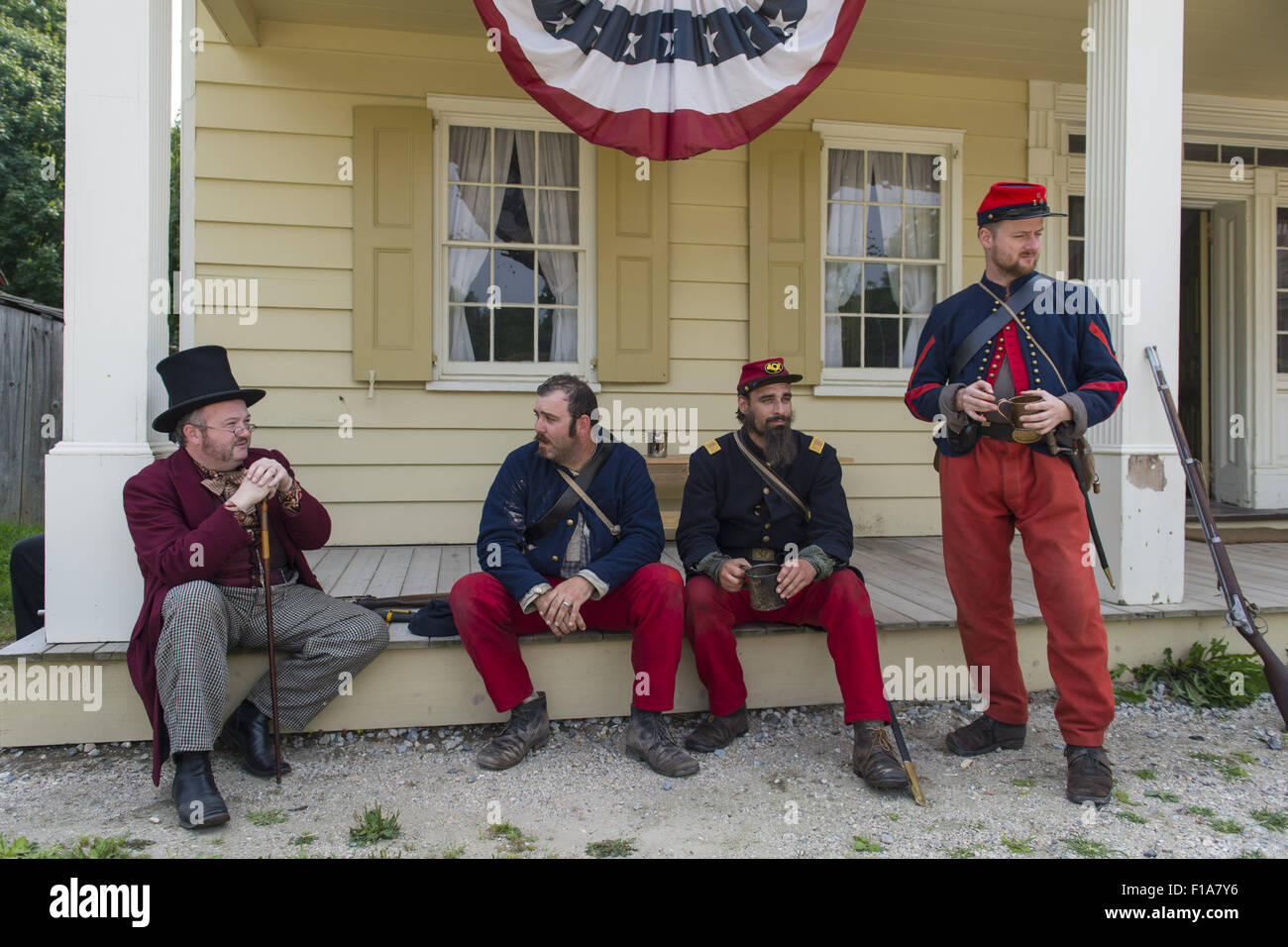 Old Bethpage, New York, USA. 30th Aug, 2015. L-R in soldier uniforms, Sean Sullivan from Greenlawn, Andrew Preble from Long Beach, and Matt Dellinger from Brooklyn, portray American Civil War soldiers from the 14th Brooklyn Regiment (14th New York State Militia) AKA The Brooklyn Chasseurs, at the Noon Inn tavern during the Old Time Music Weekend at the Old Bethpage Village Restoration. During their historical reenactments, members of the non-profit 14th Brooklyn Company E wear accurate reproductions of ''The ''Red Legged Devils'' original Union army uniform. (Credit Image: © Ann Par Stock Photo