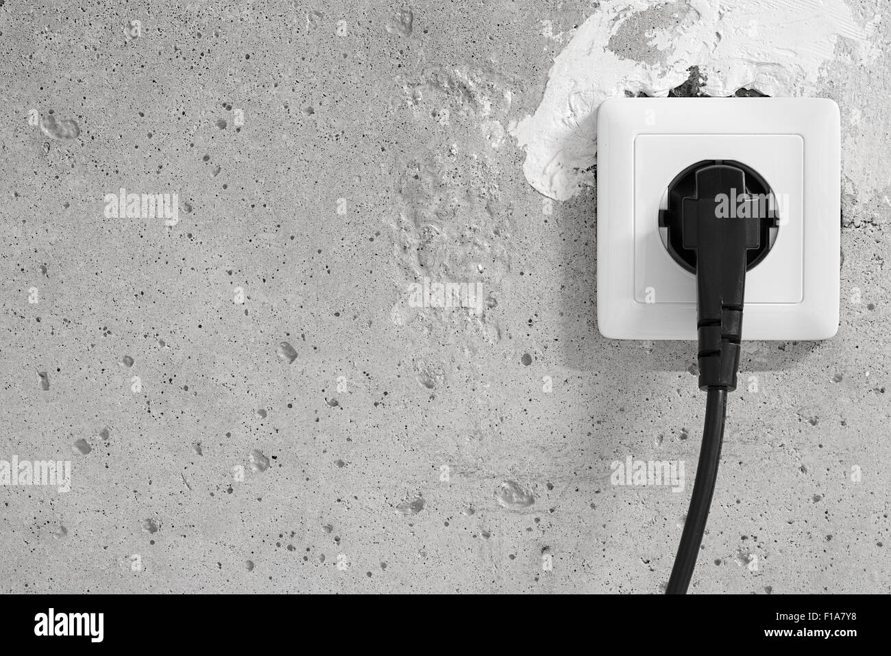 Energy, Electric Plug on a concrete wall Stock Photo Alamy