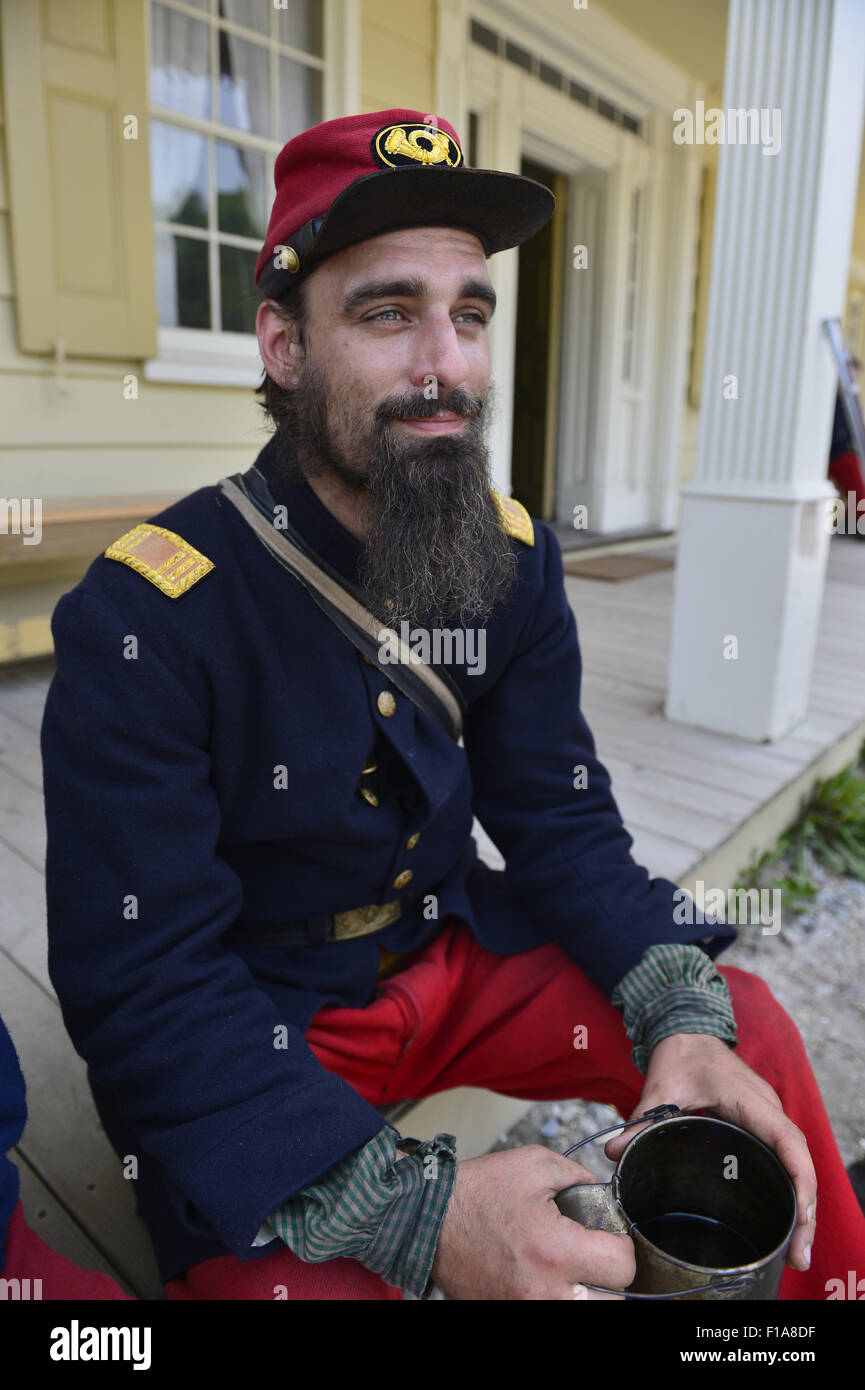 Old Bethpage, New York, USA. 30th Aug, 2015. Andrew Preble from Long Beach portrays an American Civil War soldier Captain from the 14th Brooklyn Regiment (14th New York State Militia) AKA The Brooklyn Chasseurs, at the Noon Inn tavern during the Old Time Music Weekend at the Old Bethpage Village Restoration. During their historical reenactments, members of the non-profit 14th Brooklyn Company E wear accurate reproductions of ''The ''Red Legged Devils'' original Union army uniform. Credit:  Ann Parry/ZUMA Wire/Alamy Live News Stock Photo