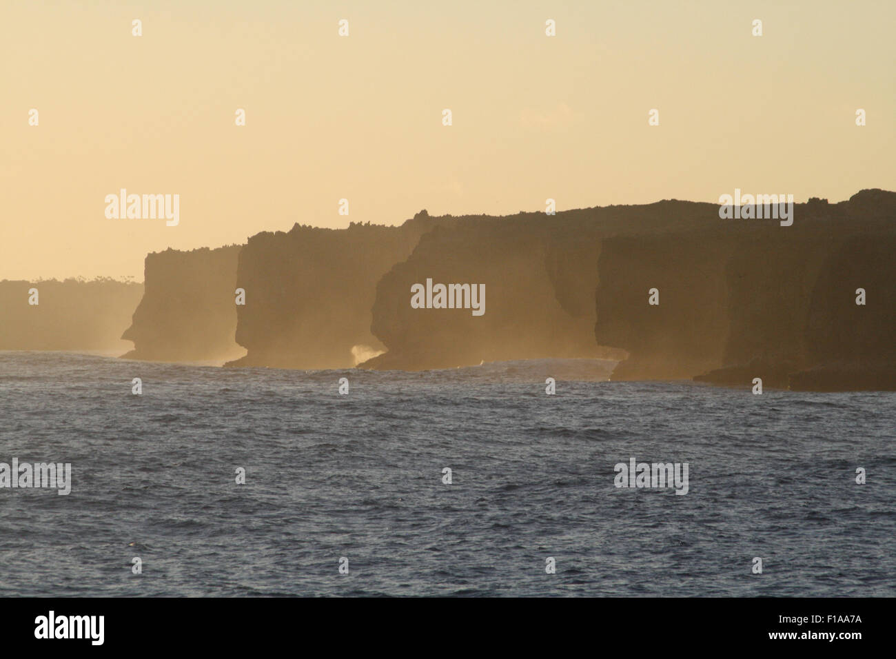 Western cliffs of Henderson Island, South Pacific at sunset Stock Photo