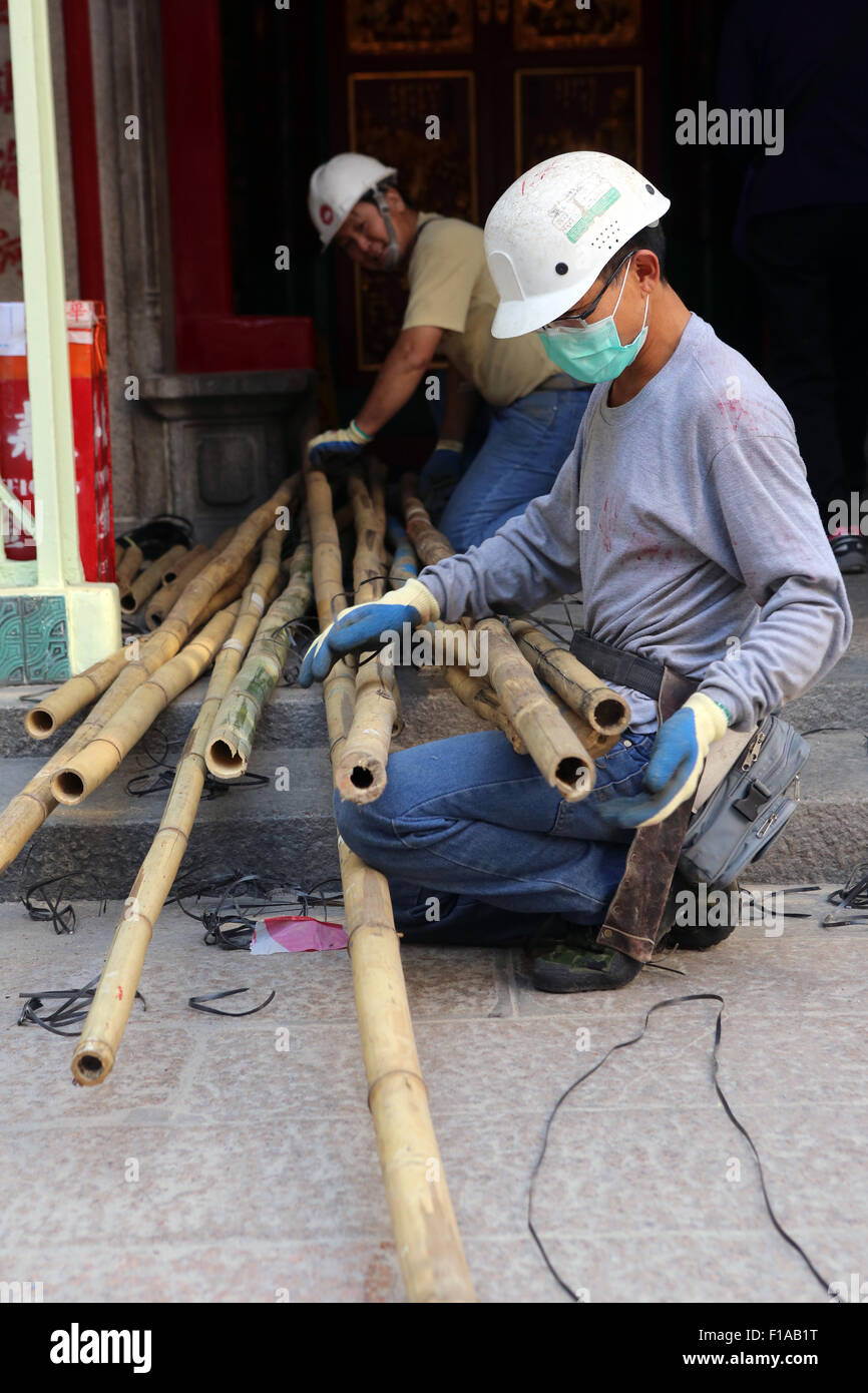 Hong Kong, China, construction worker kneels before long Bambusstaeben Stock Photo