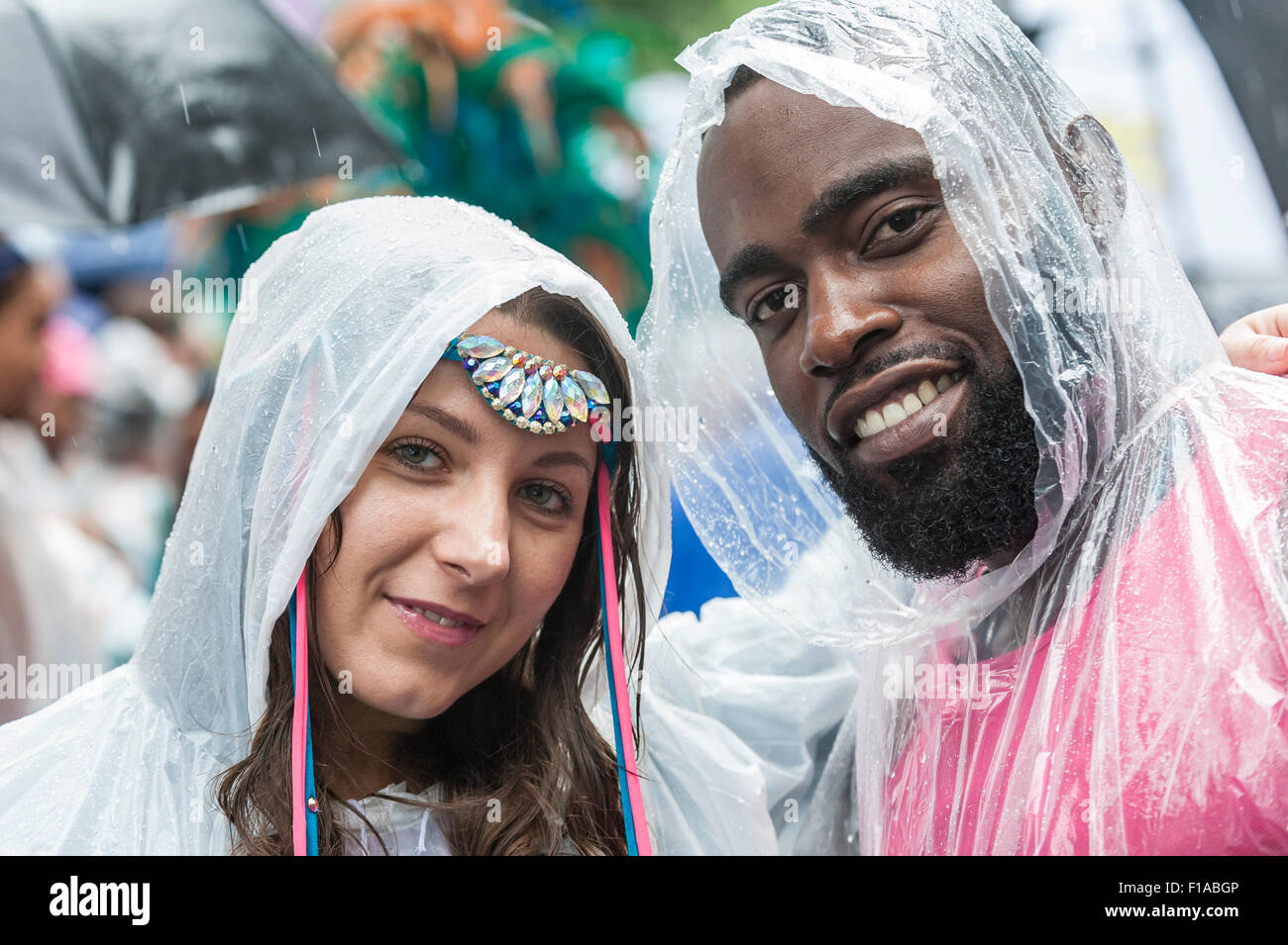 London, UK.  31 August 2015.  Dancers wearing rain ponchos at the start as heavy rain does not dampen the spirits of those taking part in day two of Notting Hill Carnival in west London. Credit:  Stephen Chung / Alamy Live News Stock Photo