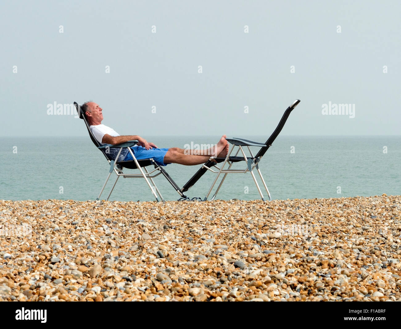 Man relaxing on Deal Beach Kent UK Stock Photo