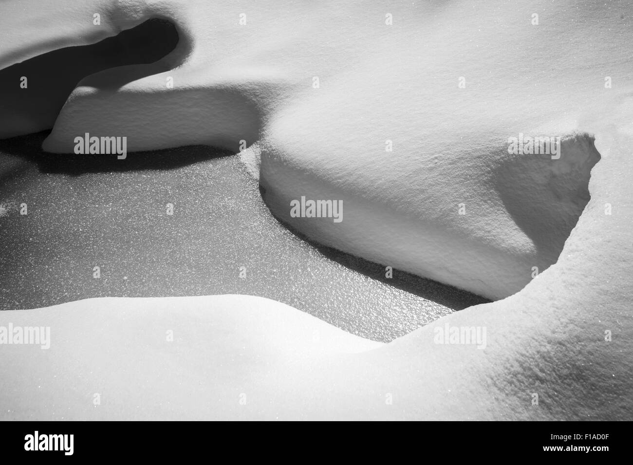 Snow Covered Rocks In Frozen Stream Stock Photo