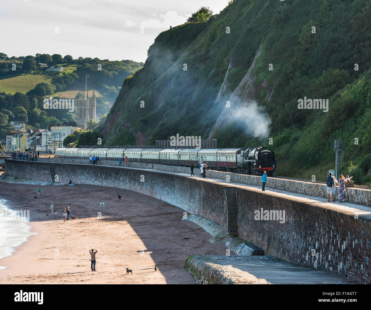 The Torbay Express steam train moves along the Brunel coastal line at Teignmouth in Devon en route from Paignton to Bristol. Stock Photo