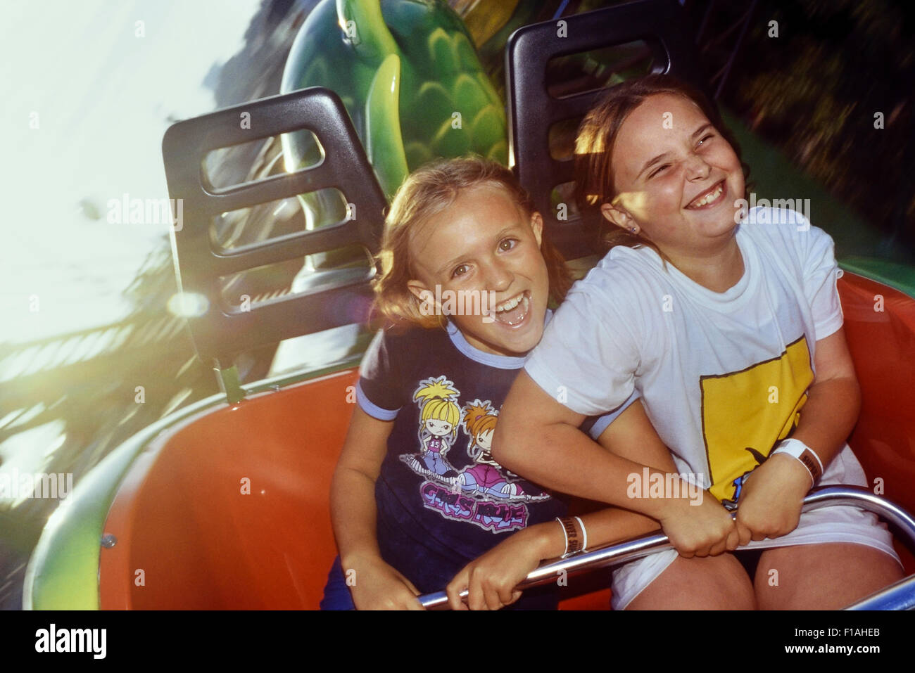 Two girls screaming on the green scream roller coaster at Pleasure Island. Southend. Essex. UK Stock Photo