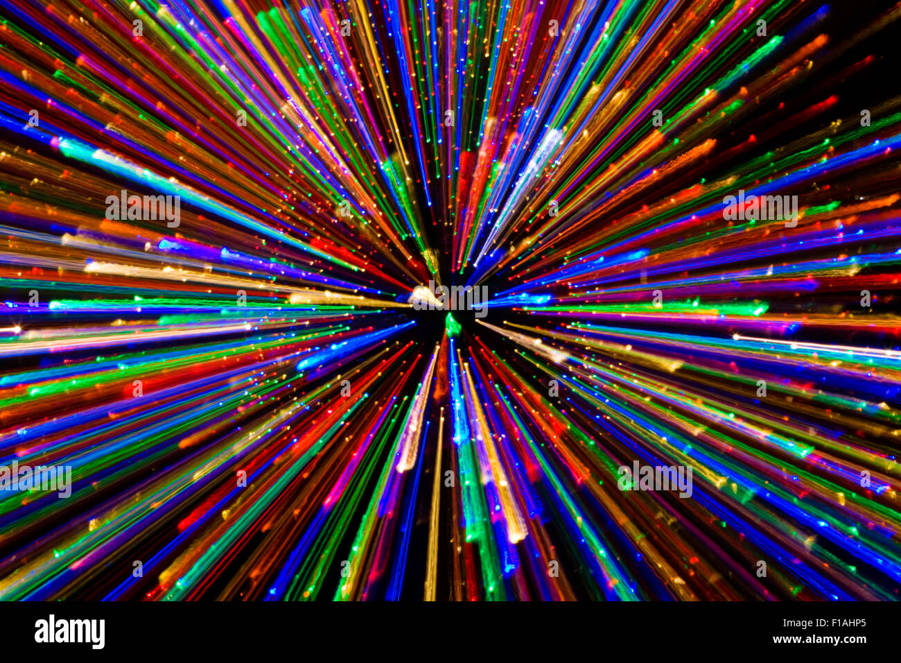 An explosion of vivid colour bursting out to the edge of the image from the middle. the graphic shows light racing towards the camera Stock Photo