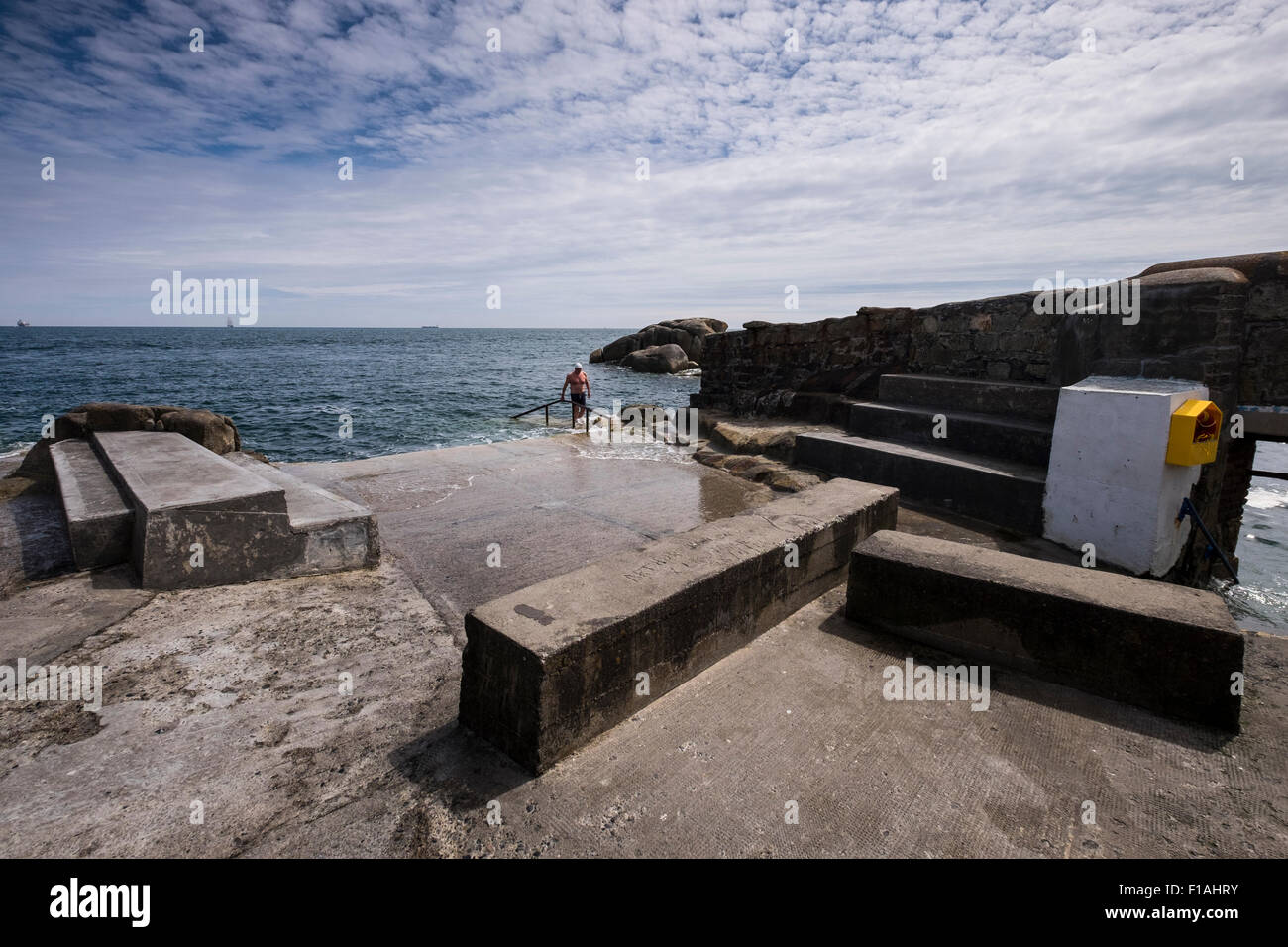 Swimmer exiting the sea at the Fortyfoot swimming place in Sandycove