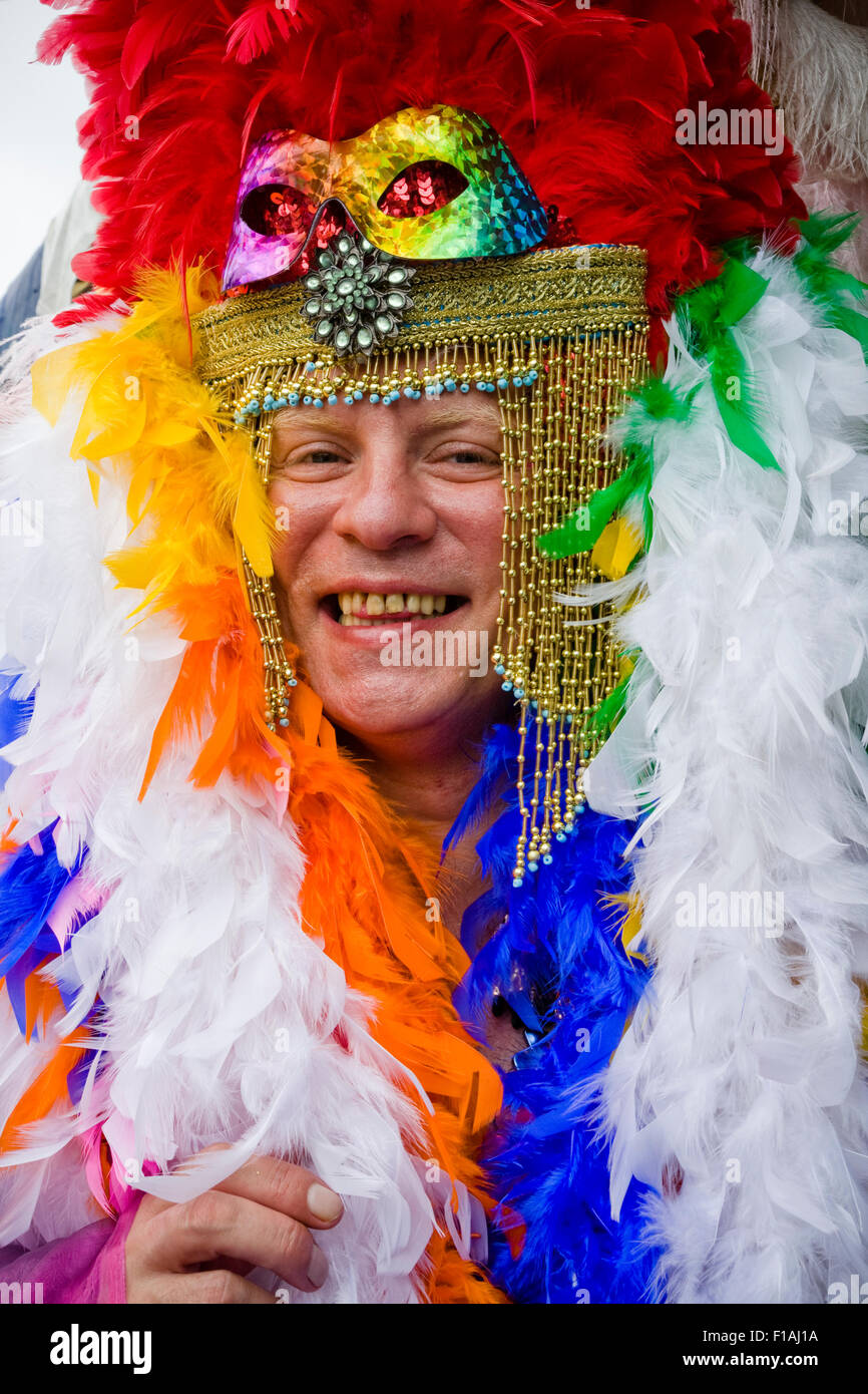Man with feather boa and headress at the main parade of Brighton Pride, Brighton, Sussex, England.uk Stock Photo