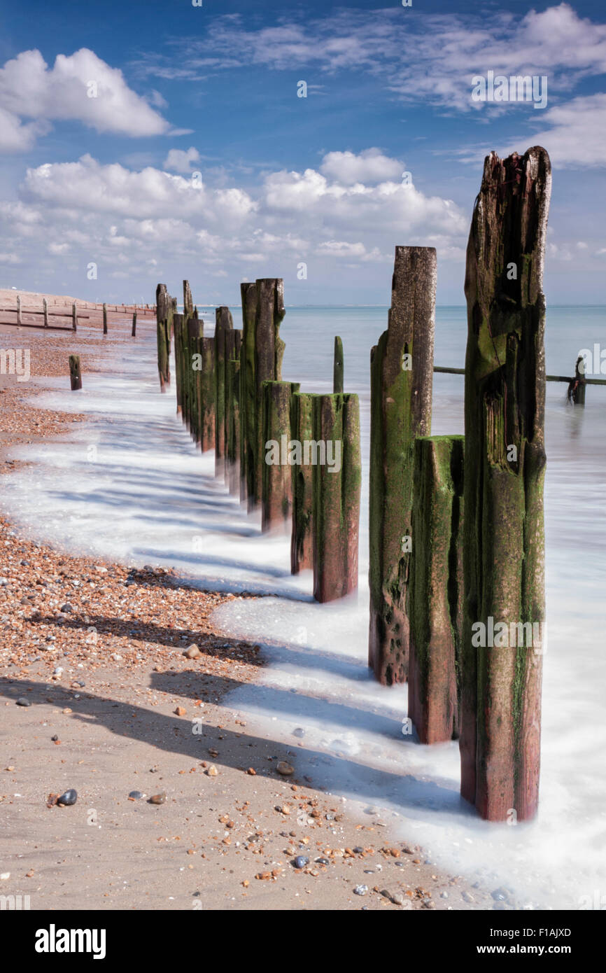 Old wooden breakwater groynes on a sunny day at Winchelsea Beach, East Sussex Stock Photo
