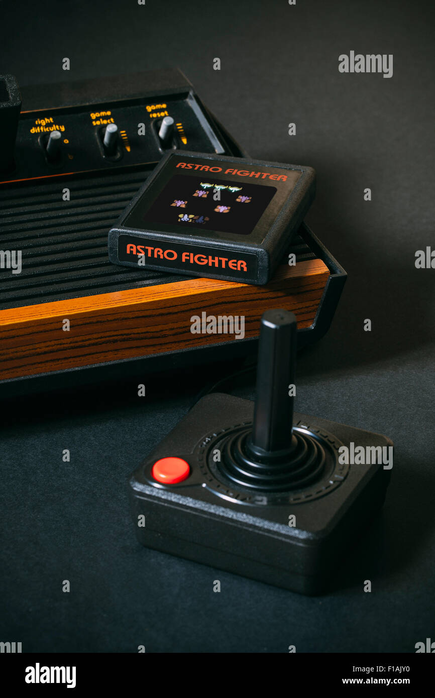 1970's Video Game Console, Atari 2600 with game cartridge and joystick. Branding has been removed and the game cartridge is of a fictional game. Stock Photo