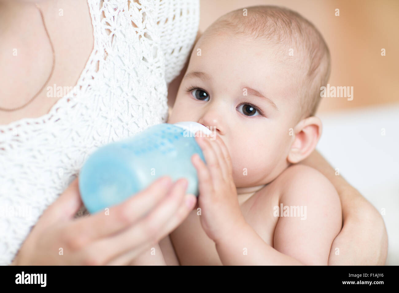 mother feeds baby milk from bottle Stock Photo
