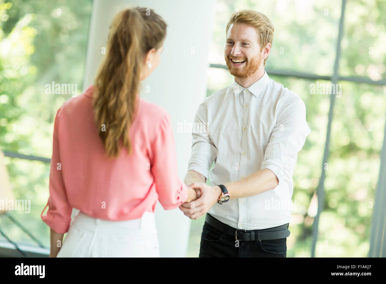 Young woman and man handshaking Stock Photo - Alamy